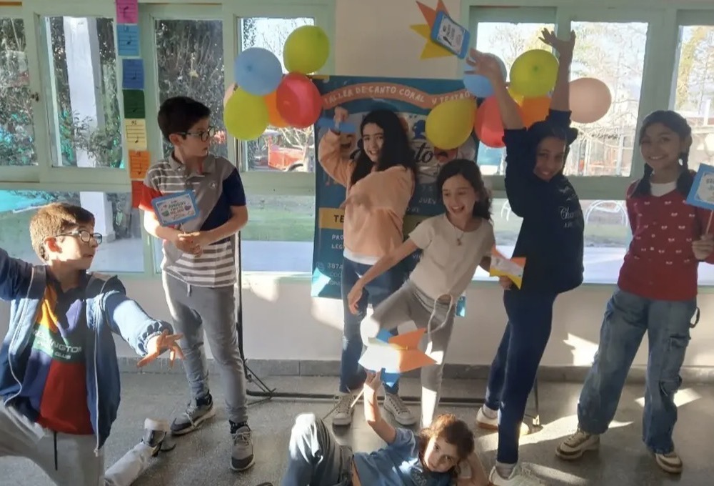 Chicos posando con globos en el taller de canto coral y teatro